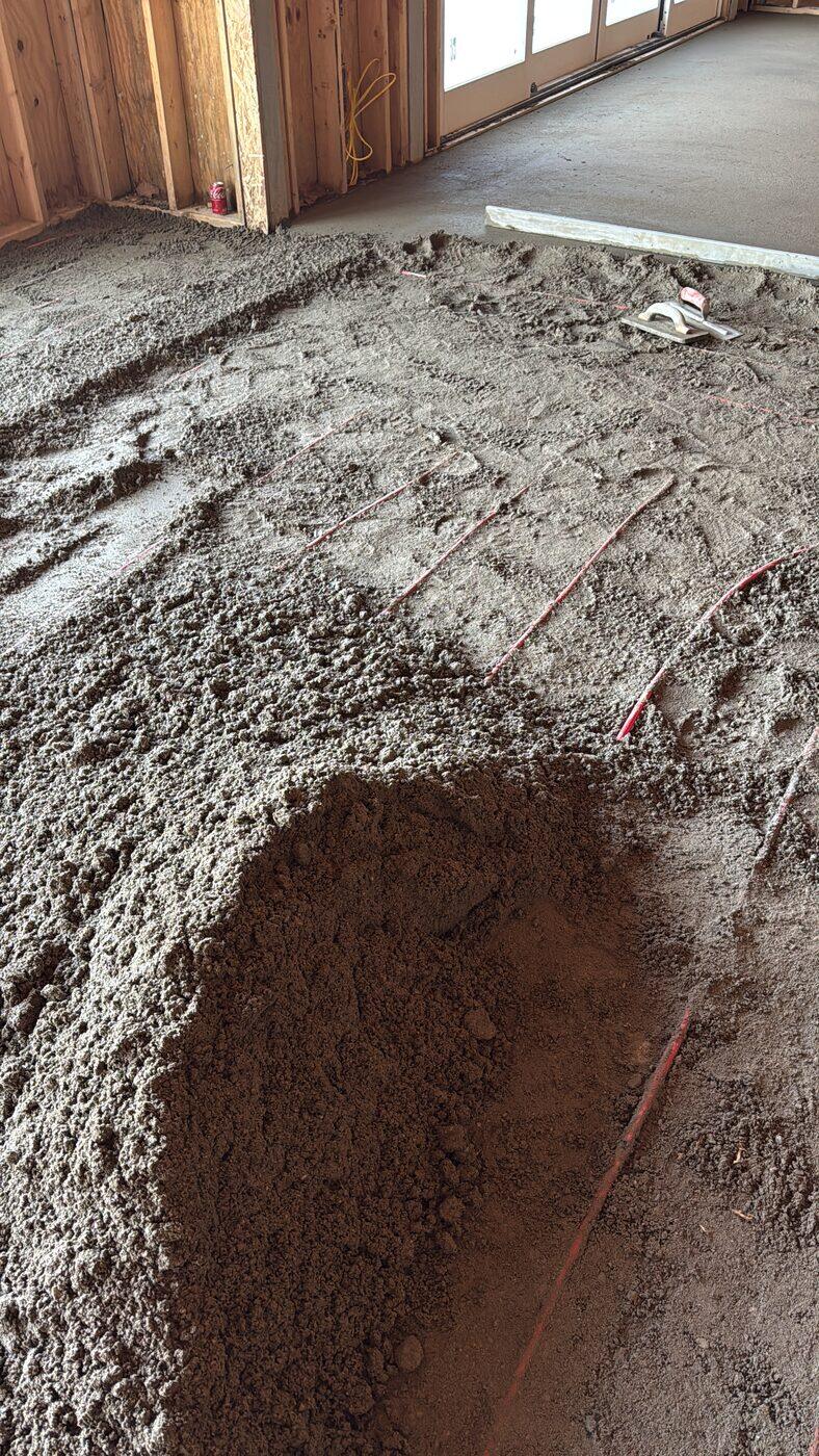 Mortar being spread and screeded over radiant tube, with a pile still to move.